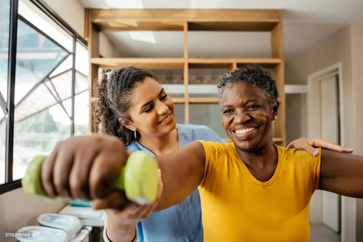 Une physiothérapeute qui accompagne une patiente dans ses exercices, en clinique.
