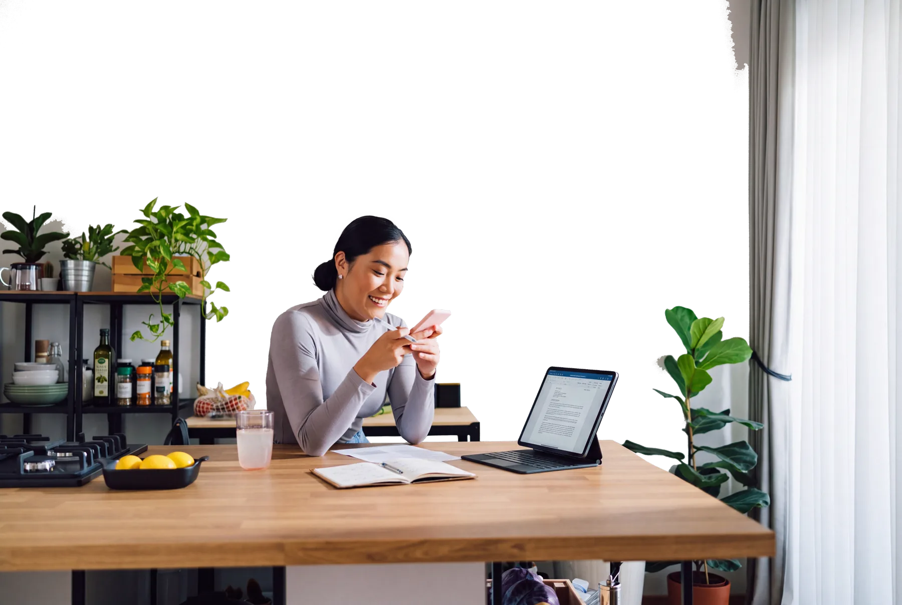 Une propriétaire de PME qui sourit en regardant son téléphone, à son bureau.